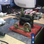 Mamod static steam engine surrounded by tools and wires after a long night's bodging to get it working again.